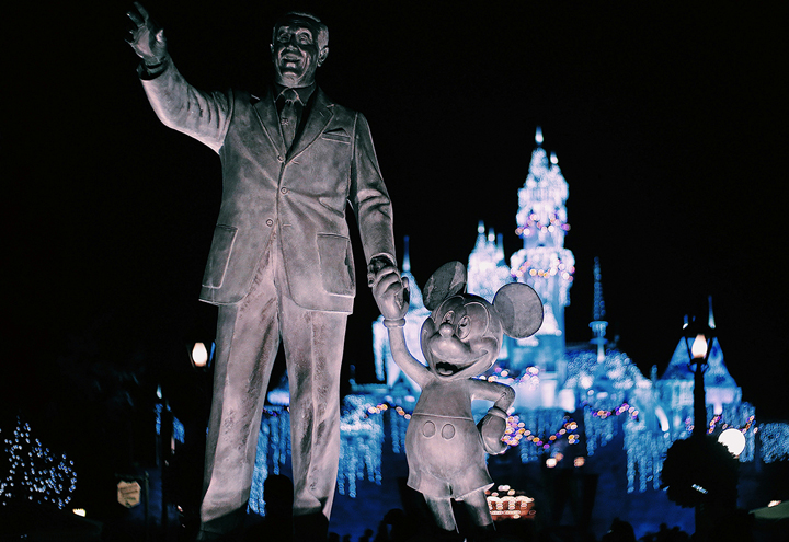 A statue of Walt Disney holding Mickey Mouse's hand invites us to hear the ghostly stories of behind the scenes at Disneyland, just down the road in Anaheim, California.